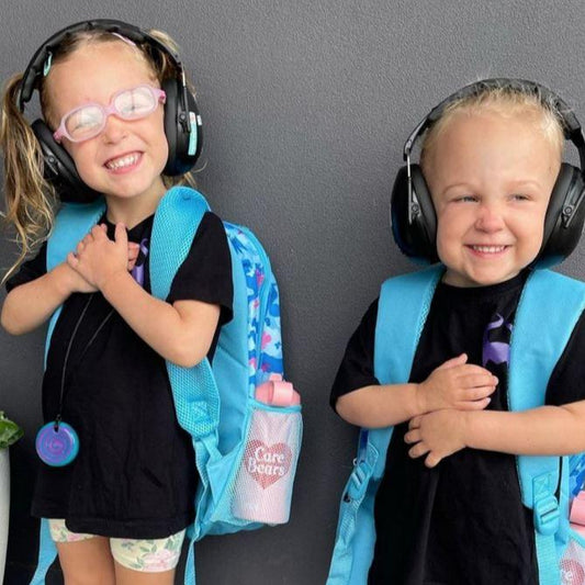 Children wearing Banz Kids Earmuffs in the Black colour option