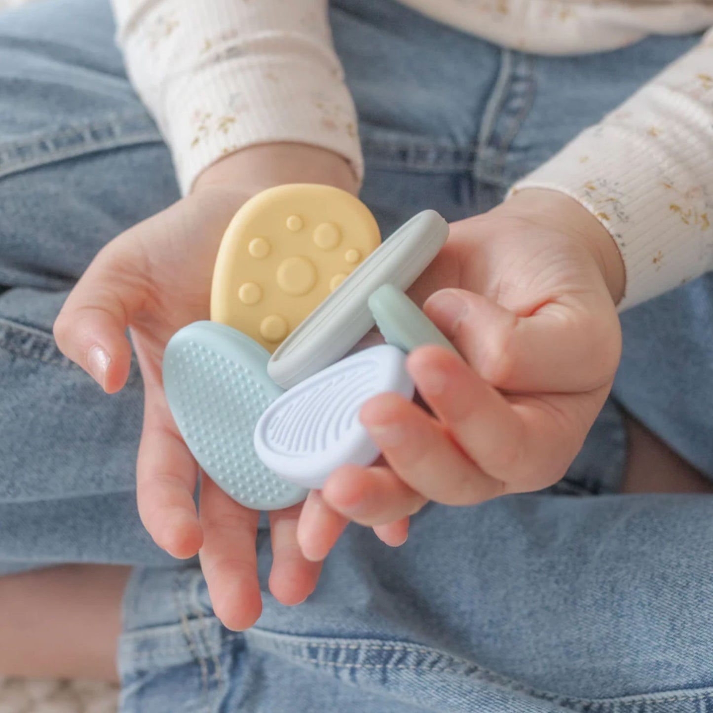 Child holding colourful silicone worry stones.
