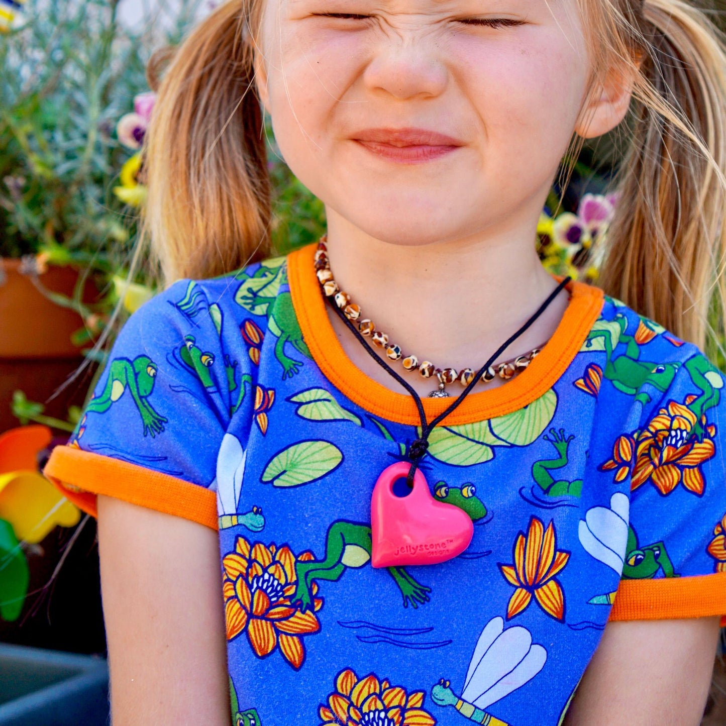 Child wearing Jellystone Designs Chew Necklace in Heart Watermelon Pink - chewies made from non-toxic food grade silicone