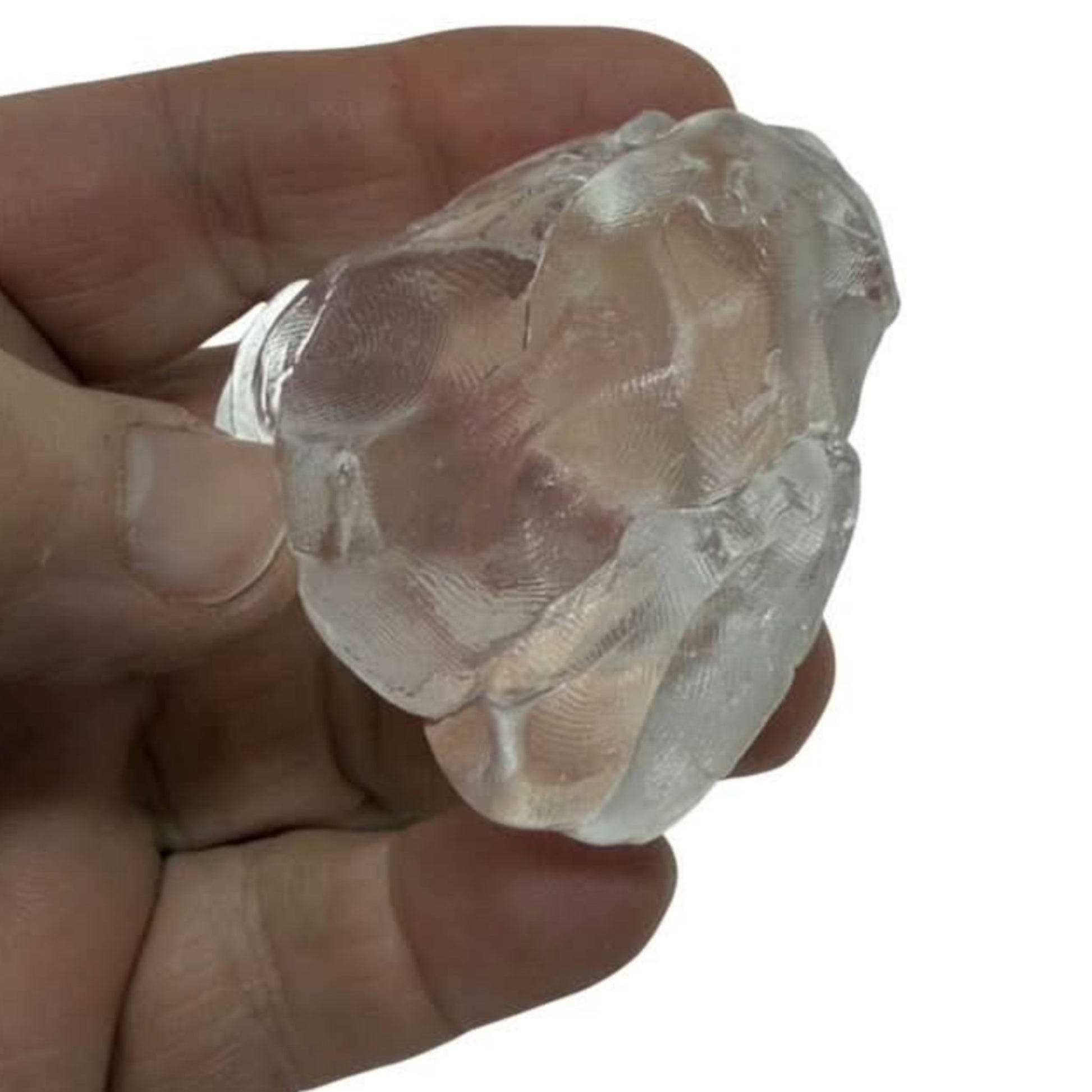 Clear putty held in a hand against a white background