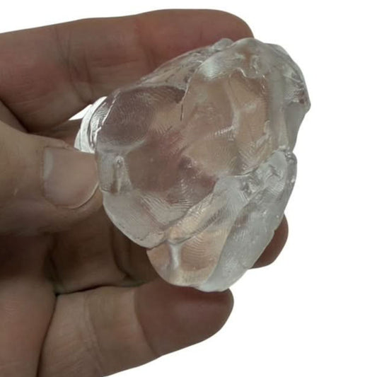 Clear putty held in a hand against a white background