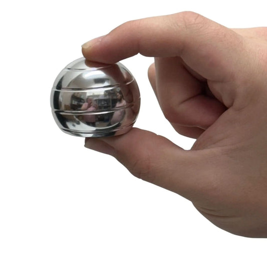 Hand holding a metallic desktop spinning fidget against a white background