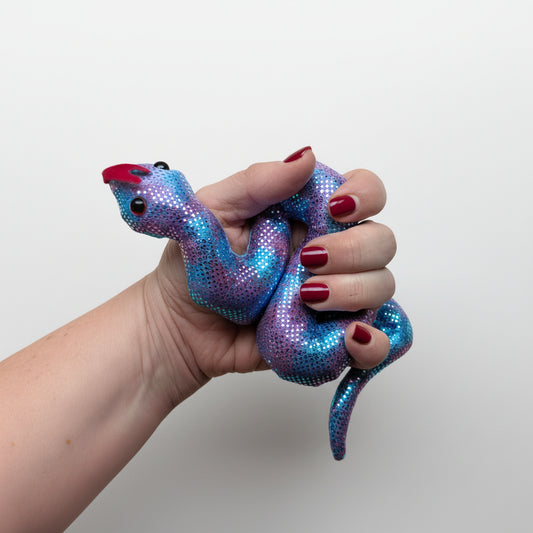 Hand holding a blue and purple snake-shaped fidget against a white background