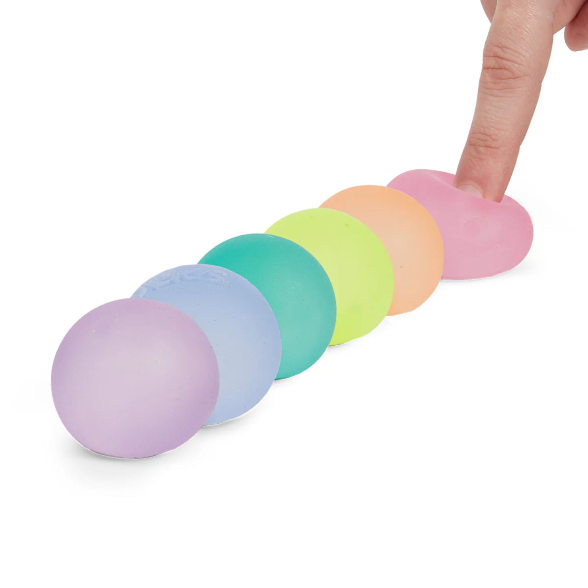 Finger squishing one of a set of six Speks memory gel stress balls in pastel colours
