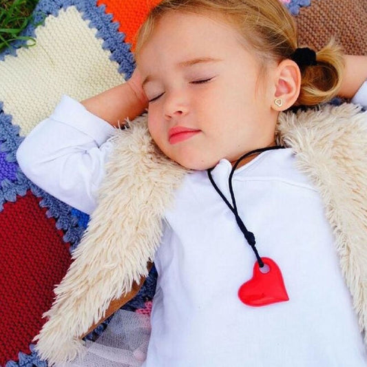 Child wearing Jellystone Designs Chew Necklace Heart in Scarlet Red