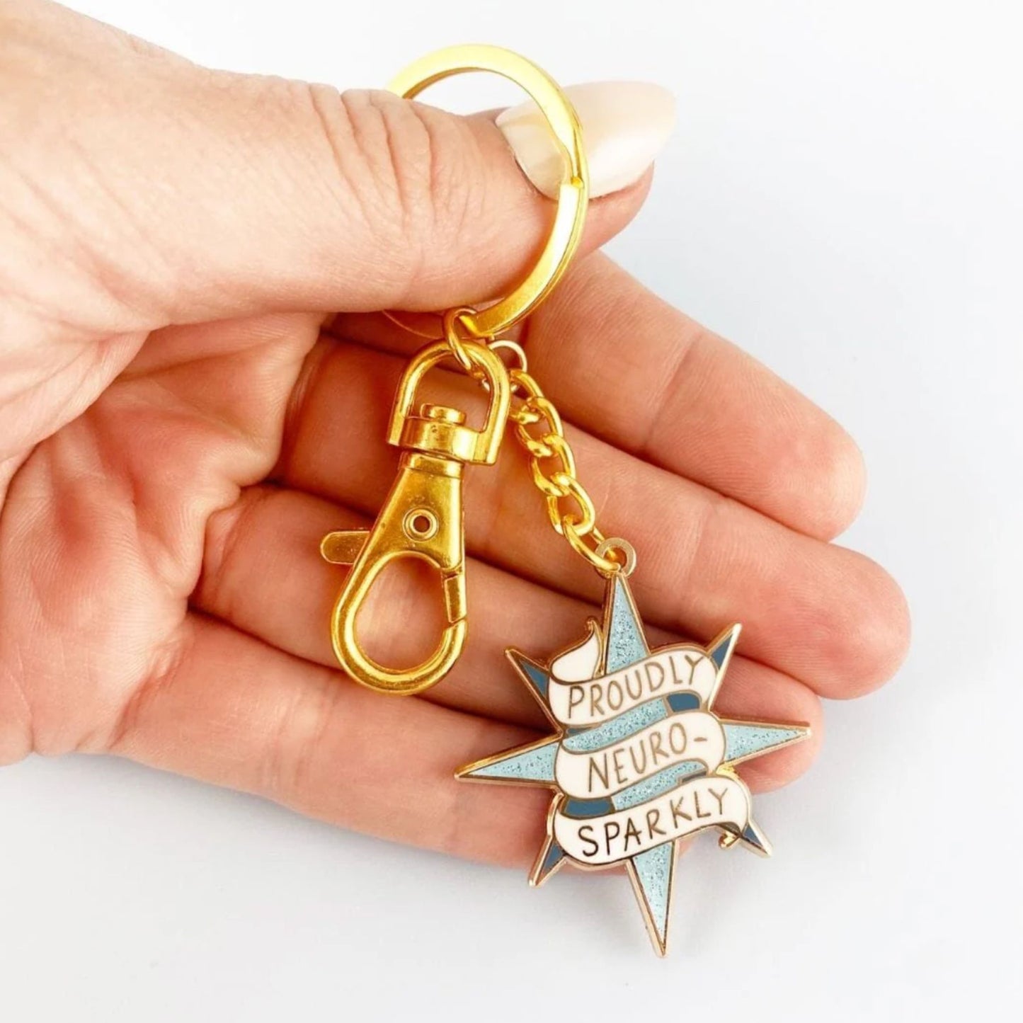Hand holding a Jubly Umph Proudly Neurosparkly Keychain