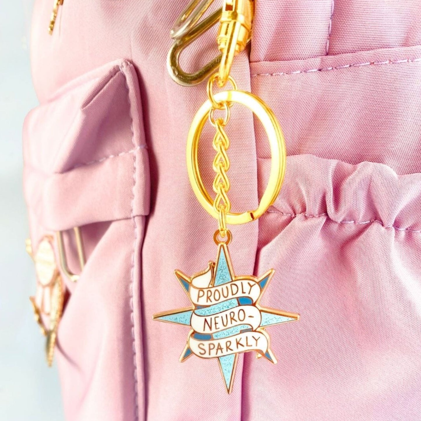 Jubly Umph Proudly Neurosparkly Keychain attached to a bag