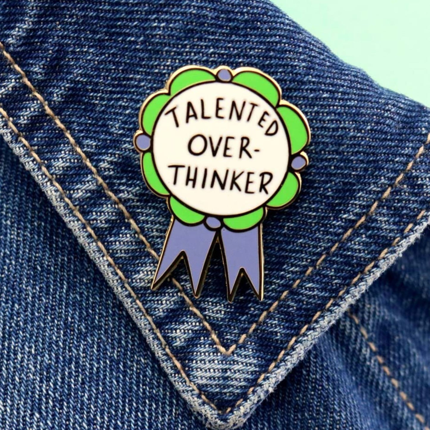 Jubly Umph Talented Over Thinker Lapel Pin worn on a jacket