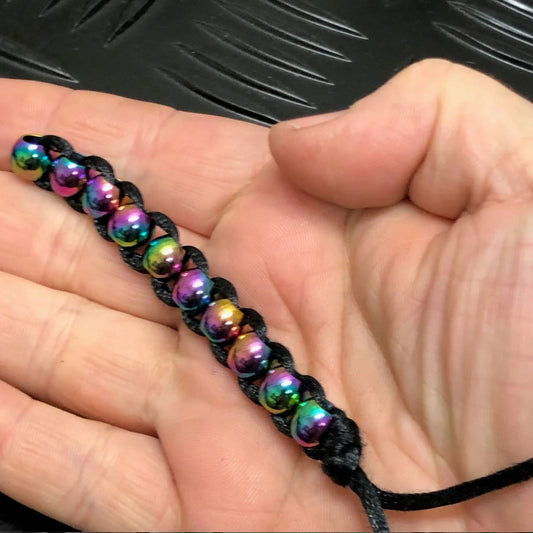 Hand holding Hand Caterpillar Fidget by Kaiko in Oil Slick