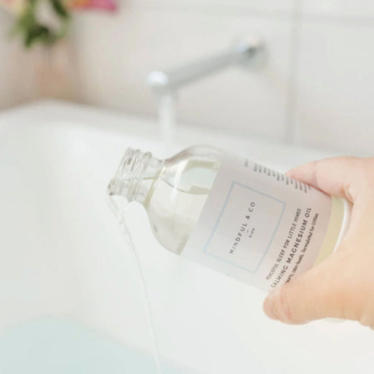 Person pouring Mindful & Co Kids Calming Magnesium Oil in a bath