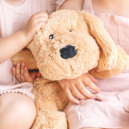 Child cuddling a Mindful & Co Kids weighted plush - Charlie the Weighted Dog