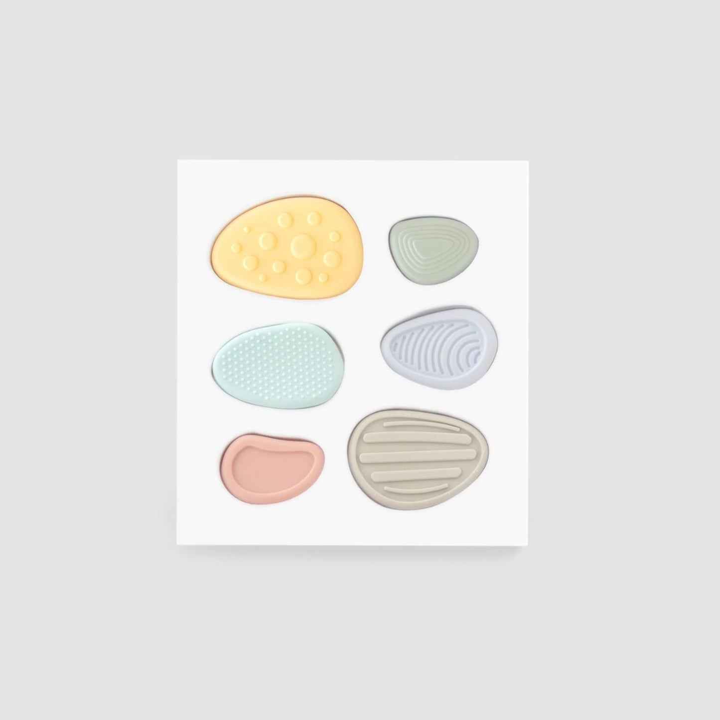 Set of six pastel-coloured silicone worry stores on a white background.