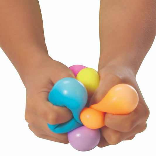 Colourful Schylling Nee Doh Rainboh squishy "groovy glob" stress balls being squeezed by hands on a white background