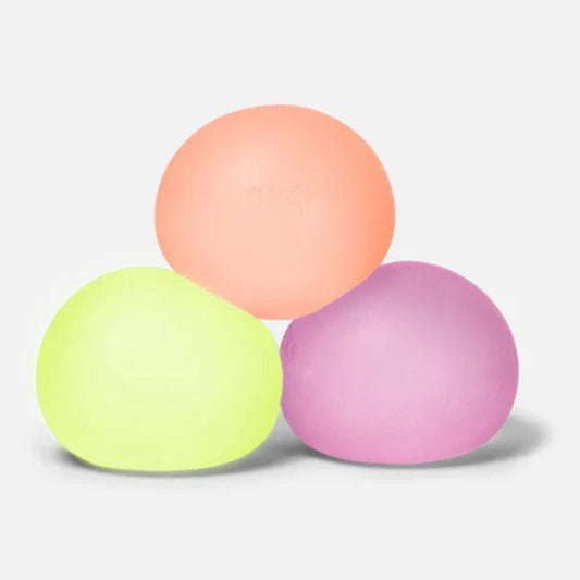 Three Speks Gumps original-size squishy stress balls in yellow, peach and pink on a white background.