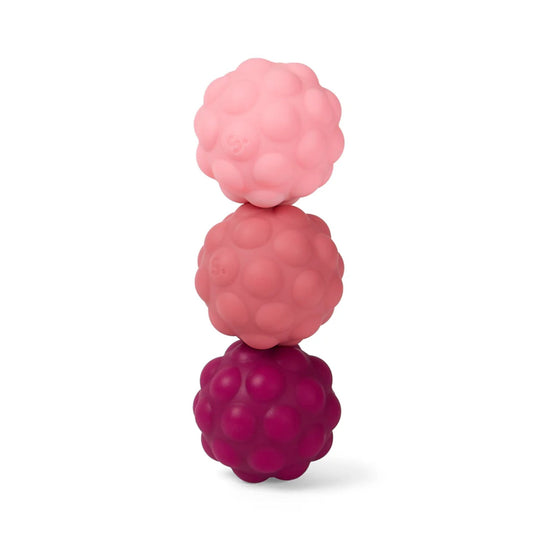 Stack of three pink textured Speks Odds silicone magnetic balls on a white background