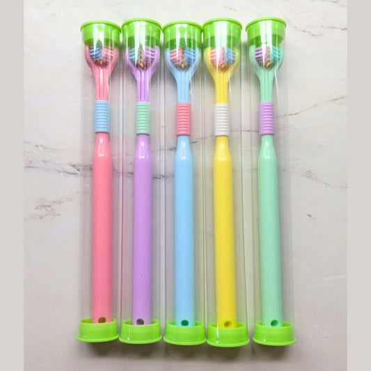 Set of five colourful sensory toothbrushes with green handles on a light gray background