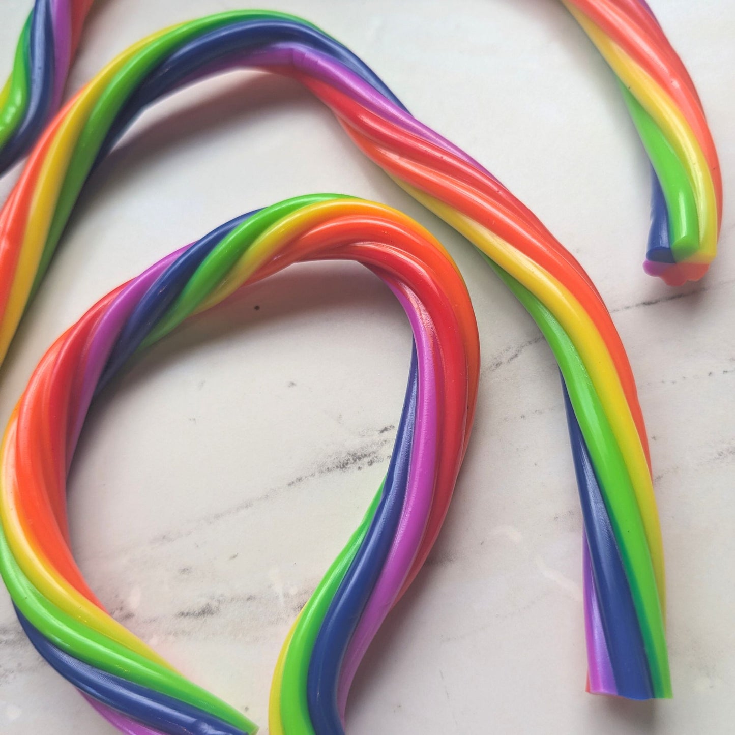 Colourful monkey noodles on a white marble surface
