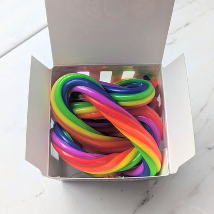 Box of colourful fidget noodles on a white surface