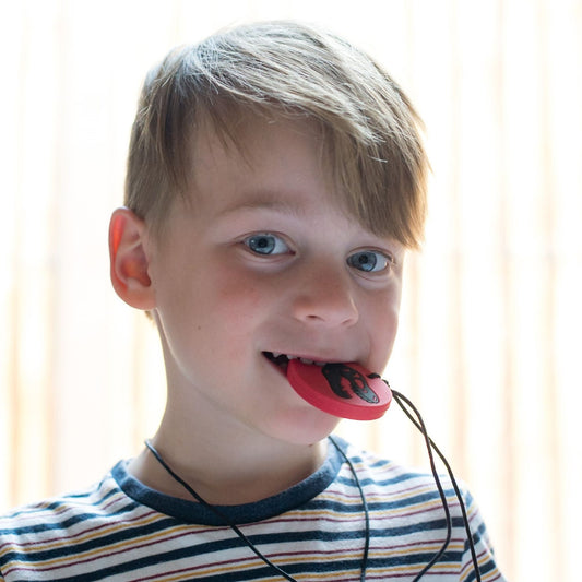 Boy biting Jellystone Designs Chew Necklace Dino in Red & Black