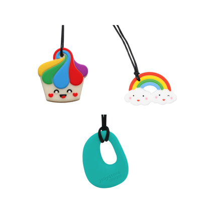 Three coloruful chewie silicone necklaces on a white background: a rainbow cupcake, a rainbow cloud, and a teal organic shape.