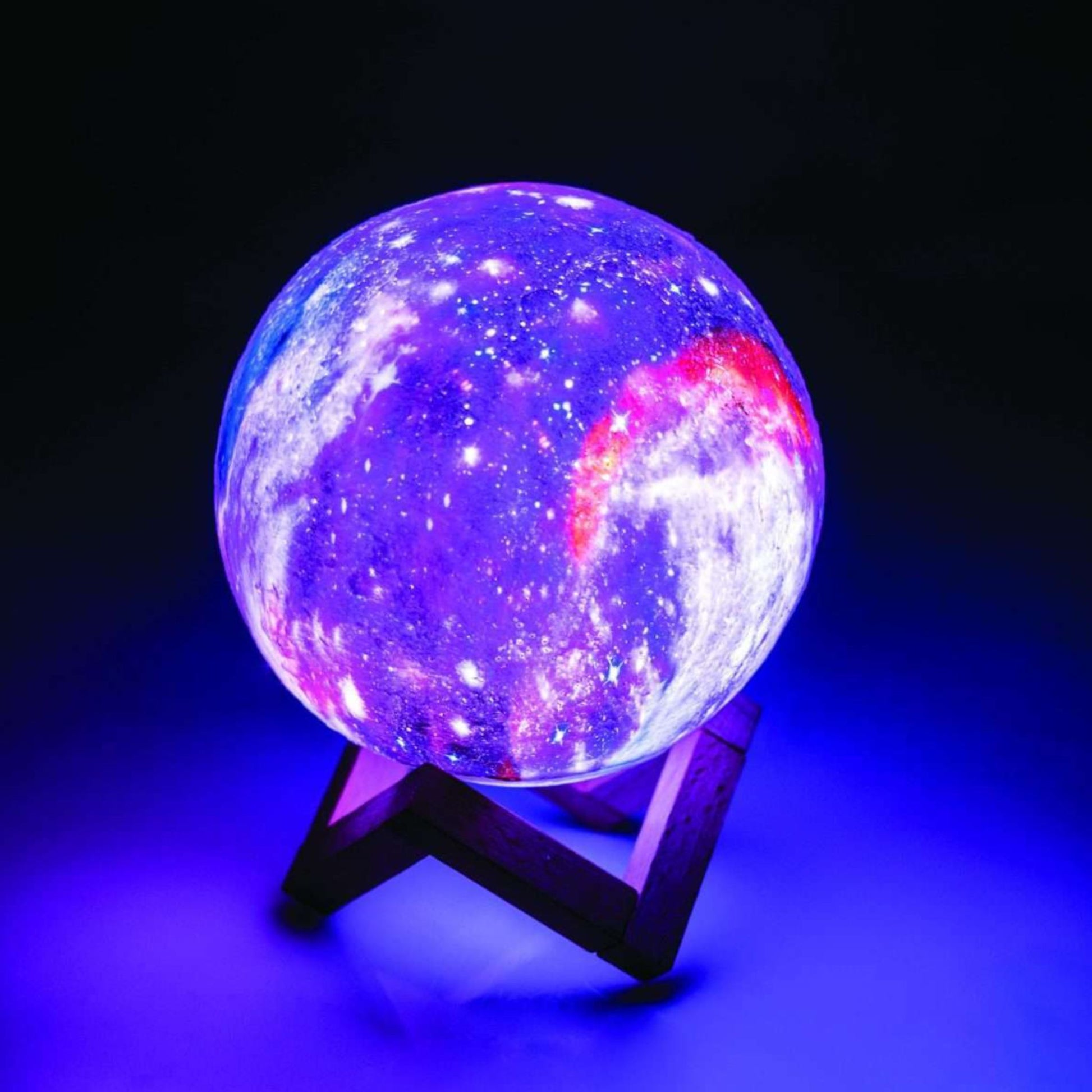 Glowing purple and blue spherical Moon Lamp on a stand against a dark background