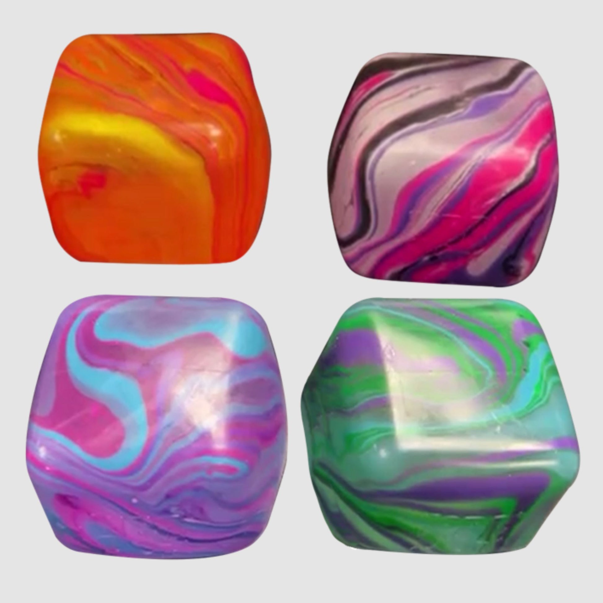 Four colourful Needoh Nice Cube Swirl marbled squishy cubes on a white background