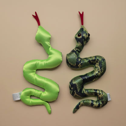Two snake-shaped toys on a light gray surface