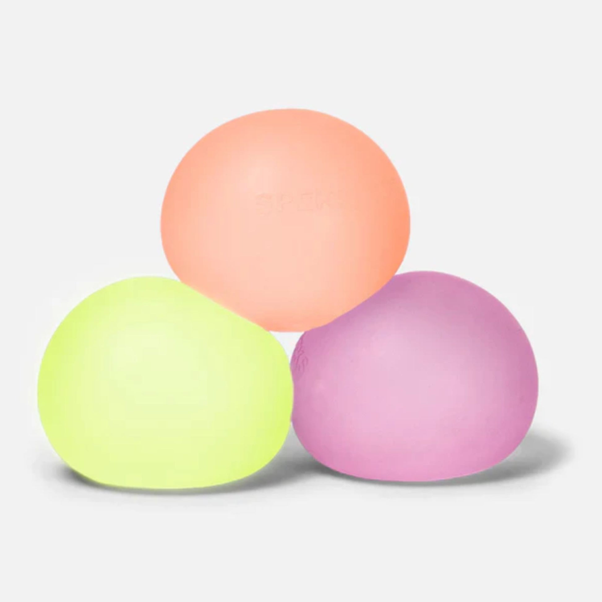 Three Speks Gumps original-size squishy stress balls in yellow, peach and pink on a white background.