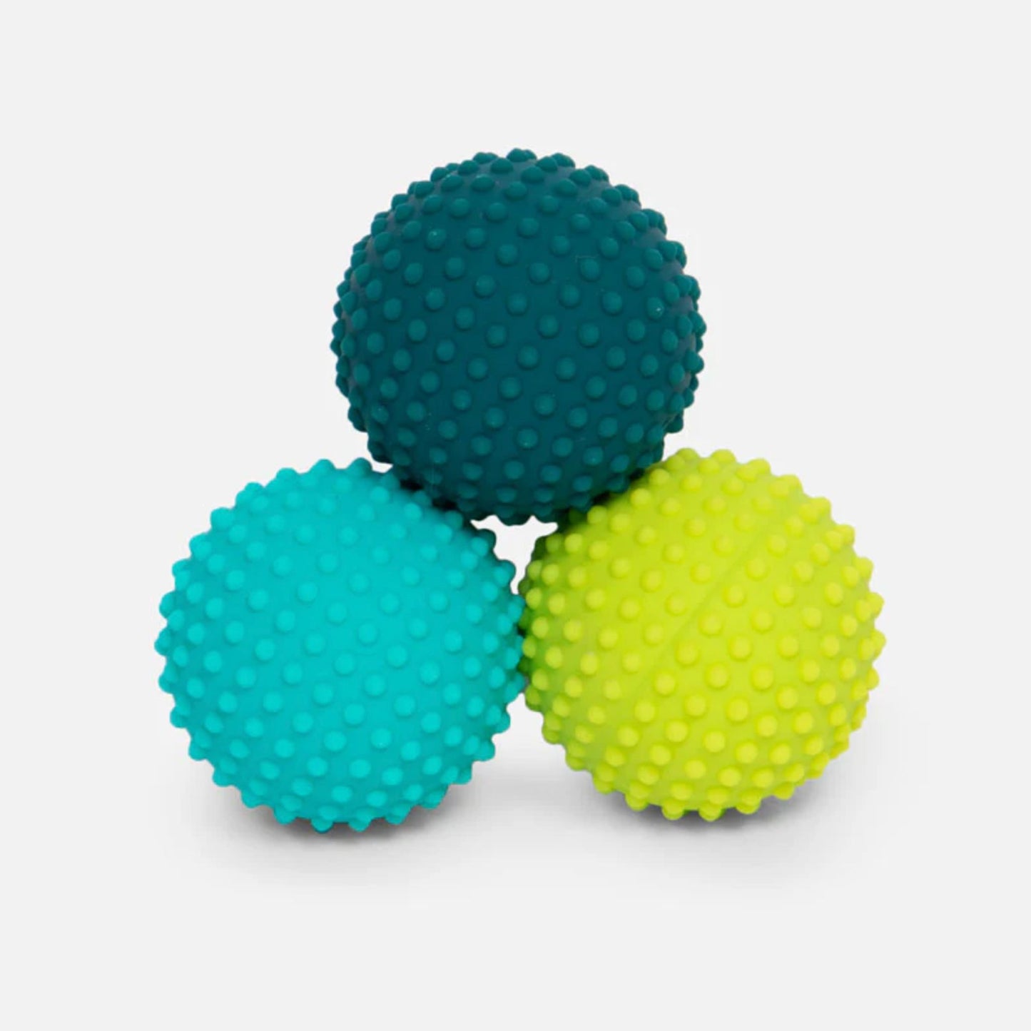 Three Speks Odds textured magnetic fidget balls for adults in teal, blue, and green on a light grey background