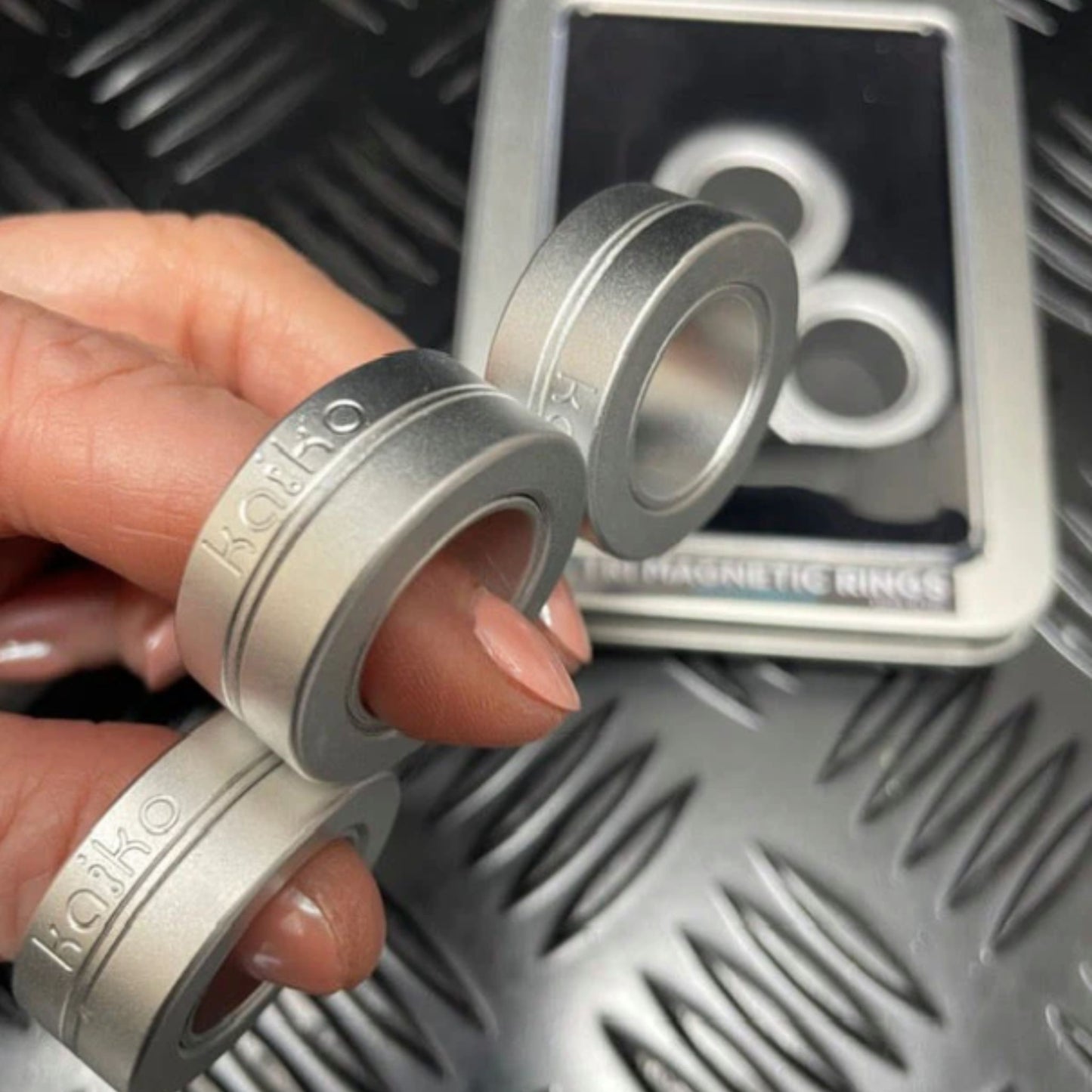 Hand holding Kaiko's Tri Magnetic Fidget Rings in a row