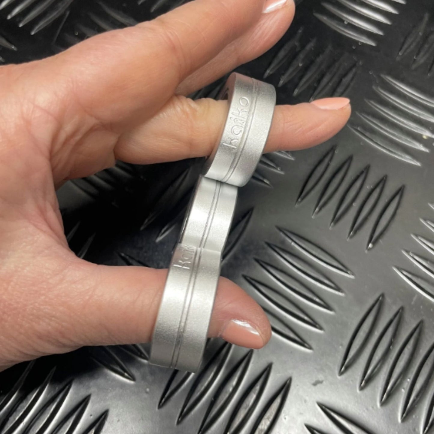Hand holding Kaiko's Tri Magnetic Fidget Rings in a row of three